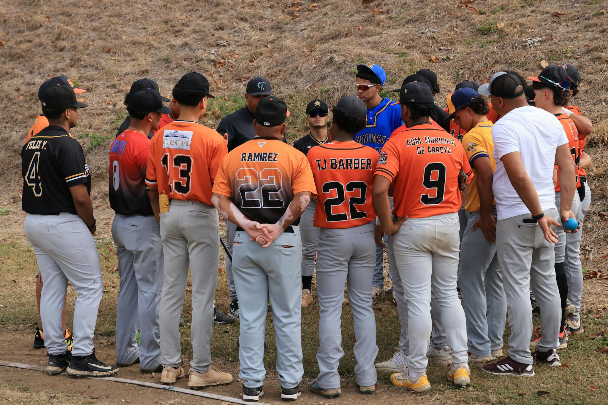 Youth baseball team gathers in a huddle during a game for strategy discussion.